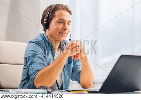 Workplace of freelance worker or sudent at home office. Young man works using computer and other devices. Remote job.