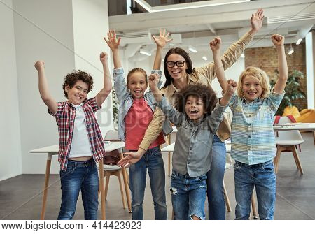 Studying Is Fun. Excited School Team Of Four Happy Little Pupils And Their Cheerful Female Teacher P