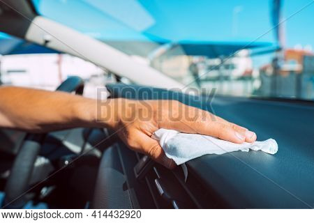Closeup Of Man Hand With Antivirus Antibacterial Wet Wipe Or Napkin Cleaning Car Panel. Man Disinfec