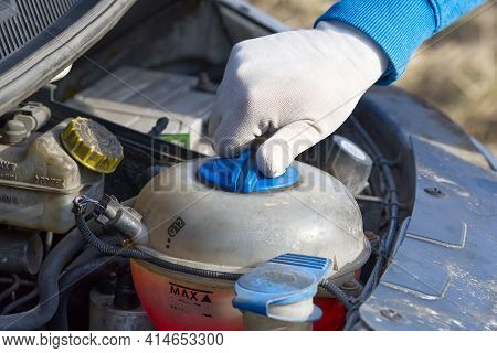 Pouring Coolant Service Of Cars. Pouring Antifreeze. Mechanic Fills The Coolant G12 To Tank In The E