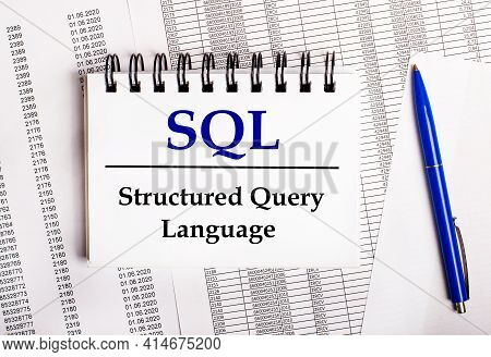 On The Table Are Charts And Reports, On Which Lie A Blue Pen And A Notebook With The Word Sql Struct