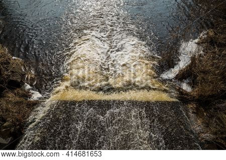 The Water Of The Fast Wild River Falls From The Concrete Locks Forming A Waterfall And Flows Into Th