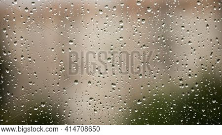 Drops Of Spring Rain On The Window Pane Flow Down Inexorably