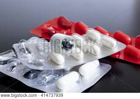 Endoscopy Capsule And Tablets On Wooden Table Close Up