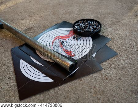 A Target For Shooting And The Barrel Of An Air Rifle. Shooting Target With Bullets And Rifle Barrel