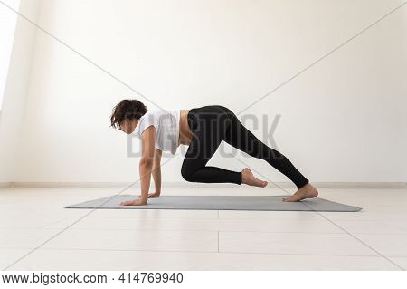 Young Flexible Pregnant Woman Doing Gymnastics On Rug On The Floor On White Background. The Concept 