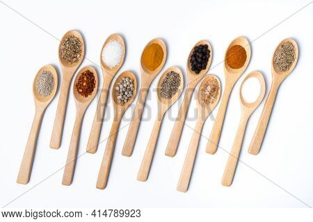 Various Spices In Wooden Spoon On White Background, Sugar, Pepper, Salt, Turmeric, Rosemary, Oregano