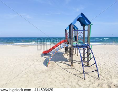 Playhouse For Kids On The Sand Near The Sea. Playground Area On The Beach, Sunny Day, Nobody. Concep