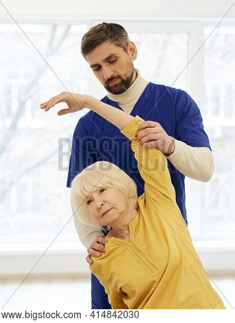 Senior Patient While Exercise Treatment With Her Experienced Physiotherapist. Rehab At A Medical Cen
