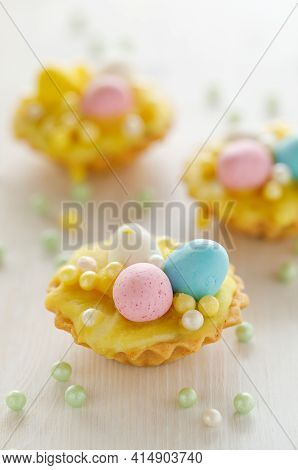 Easter Mini Tarts Decorated With Frosting And Marzipan Eggs In Pastel Colors, Close-up. Easter Delic