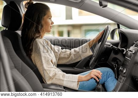 safety and people concept - young woman or female driver driving car in city