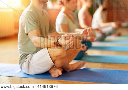 fitness, yoga and healthy lifestyle concept - group of people meditating in lotus pose at studio