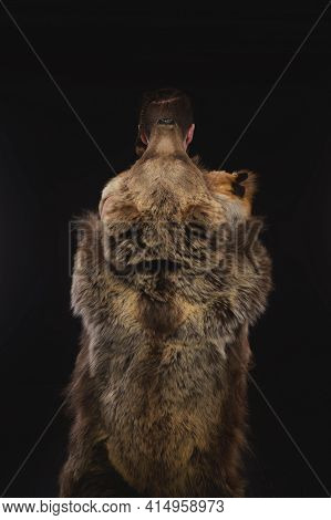 Low Key Portrait Of A Bearded War Shaman In Bearskin With An Ancient Ax In His Hands. High Quality C