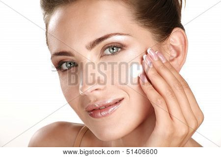 Beautiful Model Applying Cosmetic Cream Treatmen On Her Face