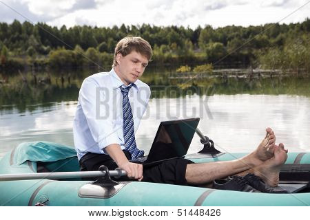 Dressed Man In Boat And Reading