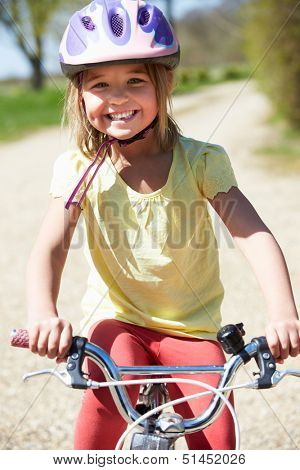 Young Girl Riding Bike Along Country Track