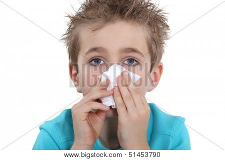 Young boy blowing his nose