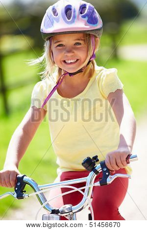 Young Girl Riding Bike Along Country Track