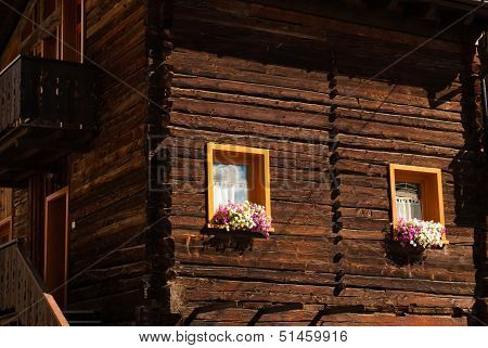 Colorful Flower Arragement on the windows of an Alpine Cabin in Austria