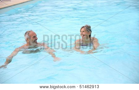 Active senior couple in resort pool