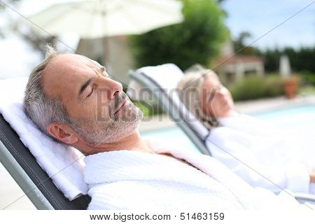 Senior man in spa hotel relaxing in long chair