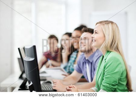 education concept - students with computers studying at school