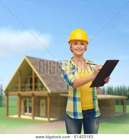 repair, construction and maintenance concept - smiling woman in helmet with clipboard