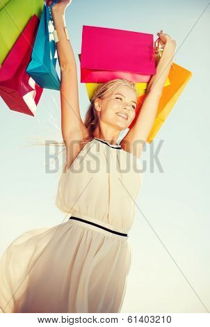 shopping and tourism concept - woman with shopping bags
