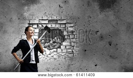 Young attractive businesswoman with hammer in hands