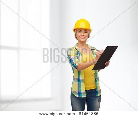 repair, construction and maintenance concept - smiling woman in helmet with clipboard
