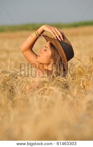 Beautiful young woman in yellow wheat grass