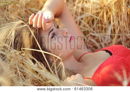 Beautiful young woman portrait in hay field