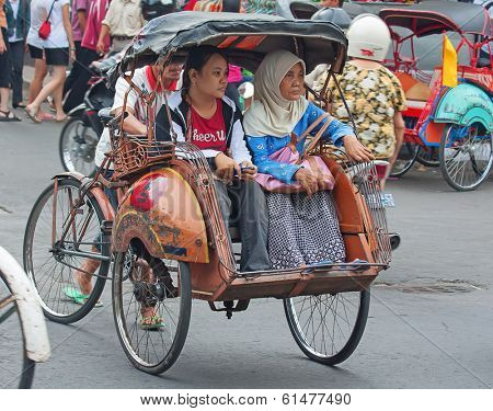 YOGYAKARTA, INDONESIA - AUGUST 03: Traditional rikshaw transport on streets of Yogyakarta, Java, Indonesia on August 03, 2010. Bicycle rikshaw remains popular means of transport in many Indonesian cities.