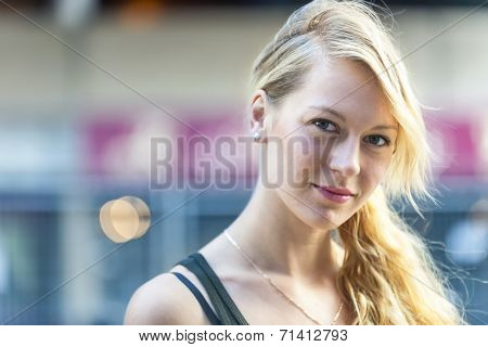 Portrait of serious young blonde woman looking at camera with copy space