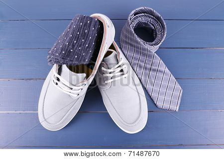 Top-Siders, socks and tie on dark blue wooden background