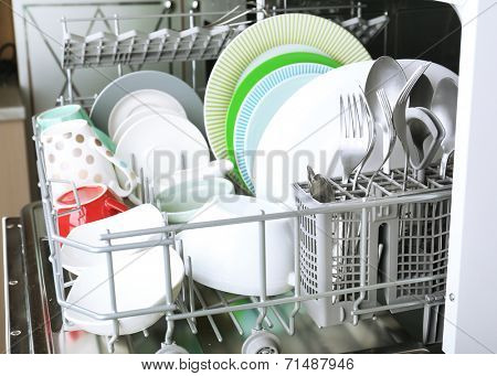 Open dishwasher with clean utensils in it