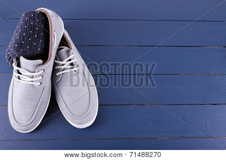 Top-Siders and pair of socks on dark blue wooden background