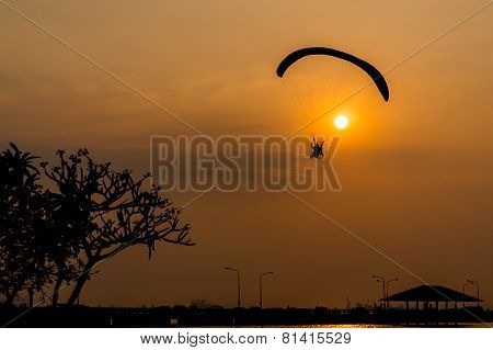 silhouette of paramotor with sunset sky