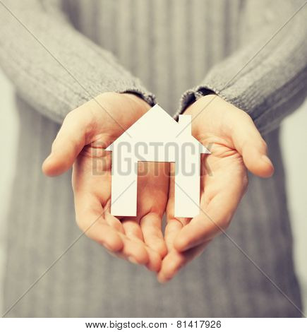 bright picture of man holding paper house
