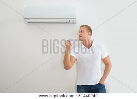 Man With Air Conditioner Remote Control
