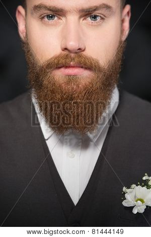 Serious man with beard looking at camera