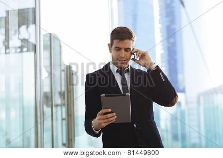 Businessman using a mobile phone and digital tablet