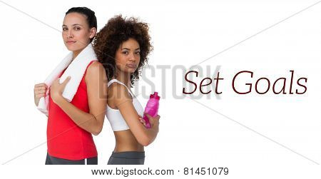 Portrait of two fit young women standing with waterbottle and towel over white background