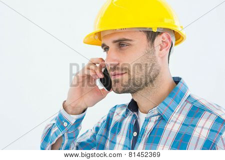 Male construction worker using mobile phone against white backgorund