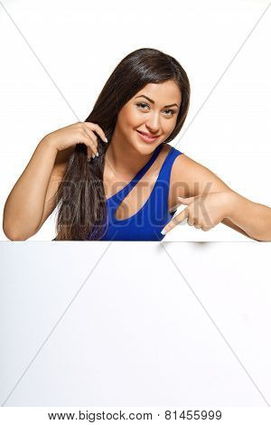 Young pretty woman peeking out from behind the wall