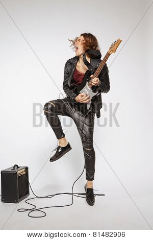 Young guitar player isolated on grey