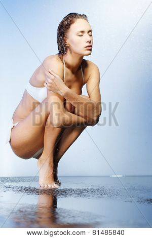 Beautiful young woman in water splashes