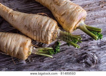 Fresh parsnip on old wooden table.