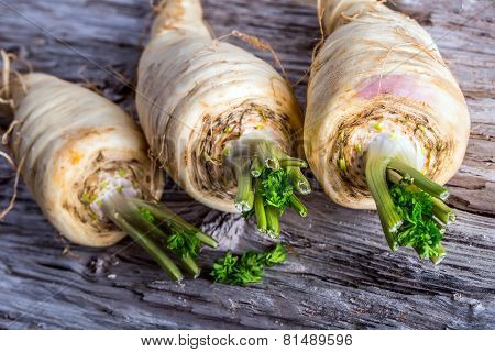 Fresh parsnip on old wooden table.