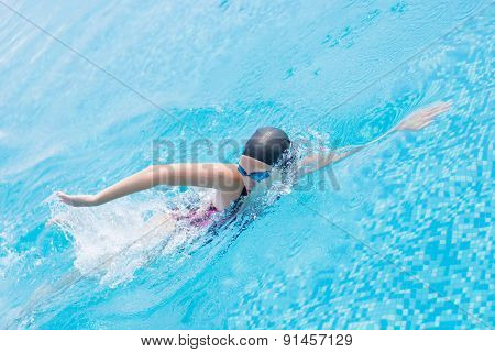 Woman in goggles swimming front crawl style